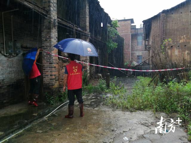 黨群志愿者冒雨拉起警戒線。